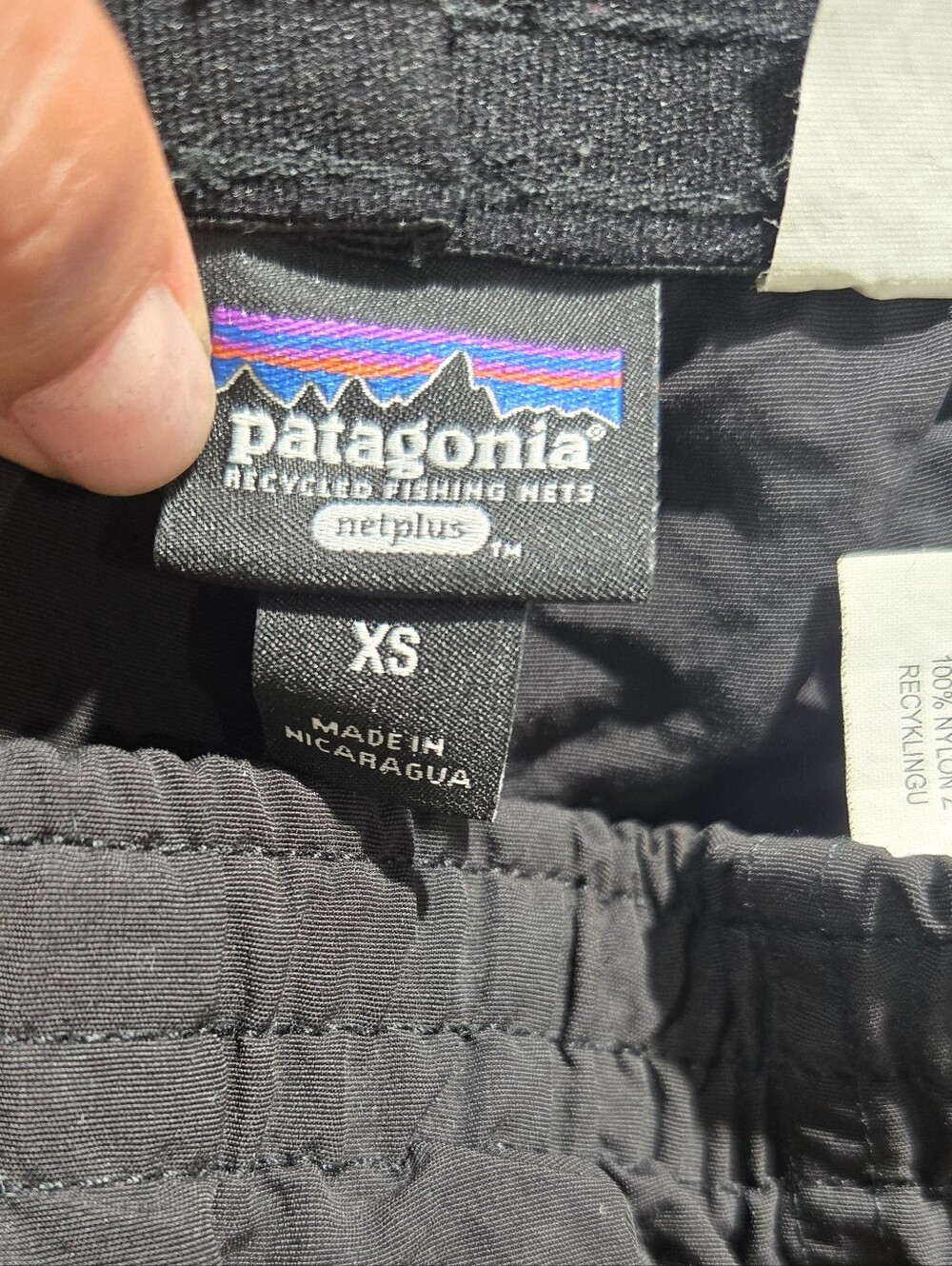 Patagonia Baggies shorts featuring a prominent woven logo patch on the left leg. - Picture 3 of 3